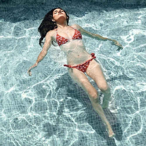 woman floats on her back in swimming pool