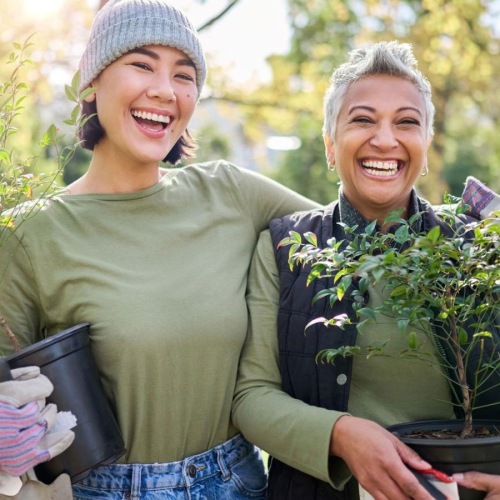 a couple of women holding plants